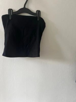 Svart tubtopp från New Yorker (oanvänd) - Jag säljer min svarta tubtopp från new Yorker. Den är lite för tajt för mig så nu säljer jag den. Den är helt ny och oanvänd!