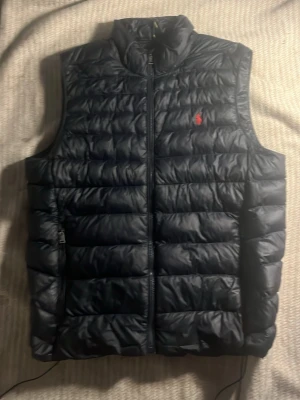 Ralph Lauren väst  - Jag säljer min Ralph Lauren väst den är jätte skön och varm. Den passar till allting här använt den några gånger men ena snöret har gått sönder men funkar lika bra som de andra. Skicka om man vill veta något mer eller ha flera bilder.