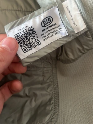 Grå vindjacka från Parajumpers - Snygg grå vindjacka från Parajumpers med klassisk design. Jackan är tillverkad i lätt och slitstark polyester, perfekt för blåsiga dagar. Stilsäker och enkel att matcha med olika outfits.