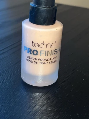 Technic Pro Finish Serum Foundation - Technic Pro Finish Serum Foundation i en ljus beige nyans. Kommer i en rund glasflaska med svart pump. Ger en naturlig finish och är lätt i konsistensen, perfekt för dig som vill ha en fräsch bas. Enkel att applicera och smälter fint in i huden.