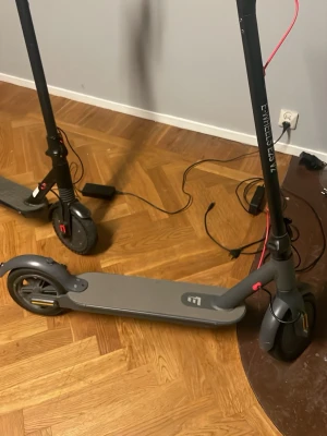 Elsparkcykel grå med röda detaljer - Säljer en elsparkcykel från E-WHEELS i snygg grå färg med röda detaljer. Den har bred fotplatta, svarta hjul och grå handtag med struktur för bättre grepp. Laddare medföljer och elscootern har en stilren och modern design. BATTERI MÅSTE BYTAS⛔️⛔️ för den kommer annars inte funka 