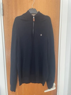 Marinblå halvzip-tröja från Morris - Stilren marinblå halvzip från Morris med liten logga på bröstet. Tröjan har ribbade muddar och krage med dragkedja. Perfekt till jeans eller chinos för en clean look.