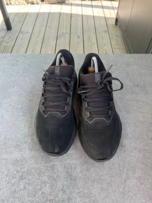 Svarta sneakers med mesh-ovandel - Snygga svarta sneakers med ovandel i mesh och syntetmaterial. Skorna har klassisk snörning och låg profil, perfekt för en clean och sportig look. Sulan är svart och ger bra grepp. Passar dig som gillar stilrena och bekväma sneakers. Mesh sönder på insidan vänster fot. Lite slitna i plösen