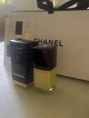 Chanel Le Vernis 129 OVNI nagellack - Chanel Le Vernis Nail Colour i nyansen 129 OVNI. Ett lyxigt nagellack i en trendig gul färg med glansig finish. Kommer i en stilren glasflaska med svart lock och klassisk Chanel-logga. Perfekt för dig som vill sticka ut med snygga naglar.Helt nytt, endast uttagen ur sin förpackning förnyat fota färgen. Trendig Chanel presentbox medföljer om man vill. 