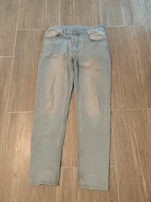 Ljusblå slim fit jeans - Säljer ett par ljusblå slim fit jeans med klassisk femficksdesign och normal midja. Jeansen har en enkel look utan synliga loggor eller detaljer, perfekta för en clean och stilren outfit. Materialet känns mjukt och stretchigt för extra komfort.