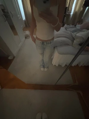 Ljusblå low waist jeans - Säljer ett par ljusblå low waist jeans med utsvängda och klassiska fickor både fram och bak. Jeansen har en snygg tvättad look och sitter tajt upptill. Perfekta för en trendig och avslappnad stil.