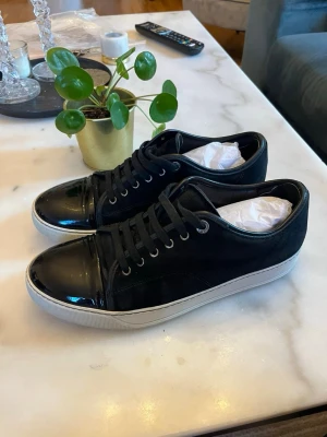 Lanvin - Svarta Lanvins i storlek uk 9 vilket motsvarar 43 i eu men passar även 44 lite defekt på insidan vid hälen men lagat och fixat så att det är som nytt igen annars är det bra skick. 