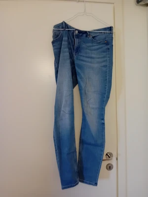 Ljusblå slim fit jeans - Snygga ljusblå jeans med slim fit passform och klassisk femficksdesign. Jeansen har en något tvättad look och raka ben. Perfekta för en avslappnad och trendig stil.