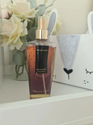 Victoria's Secret Midnight Exotics - Victoria's Secret Midnight Exotics Forbidden Vanilla är en body mist med en söt och varm doft av vanilj och sandelträ. Flaskan är genomskinlig med guldigt spraymunstycke och har en snygg gradient i rosa och guld. Perfekt för dig som gillar lyxiga och sensuella dofter. Bucklig förpackning. Säljer nu av min vintage kollektion. Perfekt för samlare. Eftersom dofterna är vintage kan lukten skilja sig markant från nya, och köps därmed på eget bevåg.