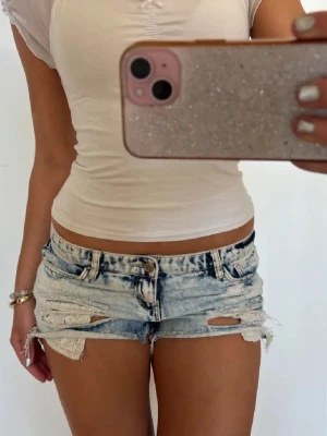 Lågmidjade shorts med spets - Såå fina ljusblå slitna lågmidjade vintage jeansshorts med spets! midjemått rakt över: 40.5. Jag är 168 och det är mina bilder, köp via köp nu direkt eller Swish, kvar tills markerad som såld 💖 