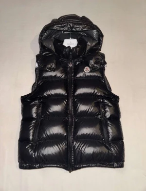 Moncler väst svart - Hejsan jag säljer nu min moncler väst som är i jättebra skick, jag har inte andvänt den så mycket kanske 2/3 gånger jag säljer den pågrund av att den inte passade min stil, den är köpt ifrån Nk Göteborg och kvittot finns, Priset är hugget i Sten,  hör av dig vid minsta lilla fråga!🙌