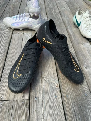 Nike Phantom Ultra Venom FG Strl 44 - Dessa goingar lämnar nu kollektionen. Släpptes i Limited Edition för 4 år sedan och har blivit het på marknaden nu på senare dagar. Säljs för 5500kr nya resell och originalpris var runt 2999kr. Har används sparsamt men har lite skråmor vid tårna. Sjukt bekväma och var en remake på de högt uppskattade hypervenom. Skick är runt 8-8.5/10. Storlek 44 och FG. Skriv vid funderingar och fler bilder.