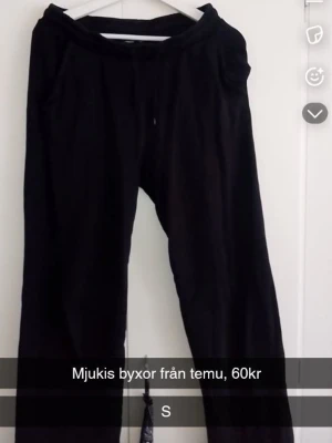 Svarta mjukisbyxor från Temu - Säljer ett par svarta mjukisbyxor från Temu med dragsko i midjan och sidofickor. Byxorna har en avslappnad passform och är gjorda i ett mjukt material som passar perfekt för chill dagar. Enkla att matcha med hoodie eller t-shirt.