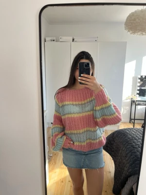 Pastellrandig stickad tröja - Säljer en fluffig stickad tröja med breda pastellfärgade ränder. Tröjan har en lös passform, ballongärmar och rund halsringning. Perfekt för dig som gillar färg och en cozy vibe.🥰