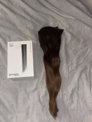 Brun clip-on löshår Rapunzel - Säljer ett långt hår från Rapunzel of Sweden i en snygg brun ombre. 50 cm clip in