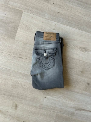 Gråa Skinny True Religion Jeans W26 - Fina True Religion Jeans i grå färg. Jeansen är i mycket bra skick och sparsamt använda. |  Äkta som allt annat jag säljer! ✅ |  Storlek: W26 | Skick: Mycket bra skick - blivit lagade. ) | Färg: Grey | Märke: True Religion | Modell: Jeans |  Hör gärna av dig vid frågor så svarar jag så fort jag kan! 😁|   (Sku - 49)
