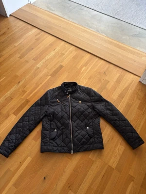 Morris jacka  - Säljer en snygg och tidlös Morris jacka. Perfekt som vår-/höstjacka. Klassisk design med rutmönster, dragkedja framtill och praktiska fickor.