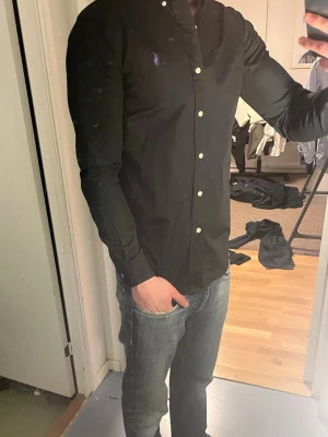 Ralph Lauren Skjorta - Tja säljer nu en Ralph Lauren Skjorta i storlek XS o färgen svart. Skjortan är i ett fint skick utan några defekter. Nypris runt 1295kr mitt pris 299kr. Hör av dig vid frågor eller funderingar