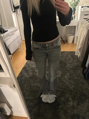Ljusgrå lågmidjade bootcut jeans  - Säljer ett par ljusblå bootcut jeans med låg midja. Jeansen har en lätt tvättad look och raka ben som går ut lite nedtill. Perfekta för en avslappnad och trendig stil. Endast använda ett par fåtal gånger, säljs pga att dom inte kommer till användning. 