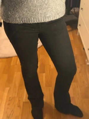 Svarta bootcut jeans - Snygga svarta bootcut jeans med klassisk femficksdesign och normal midja. Jeansen har en smal passform över låren och lätt utsvängda ben. Perfekta till en stickad tröja eller t-shirt. Materialet känns mjukt och stretchigt för extra komfort. Väldigt liten slitning som knapps märks av vid hälen⭐️