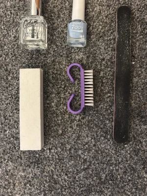 Nagelkit med lack, fil och borste - Ett komplett nagelkit med ljusblått nagellack från Depend, top coat från Glam, svart nagelfil, vit buffert och en lila nagelborste. Perfekt för dig som vill fixa snygga naglar hemma. Allt du behöver för en fräsch manikyr. Och det kommer i den där blå påsen.