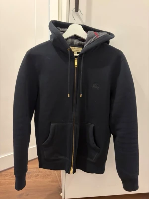 Burberry tröja  - Säljer min Burberry hoodie i svart, storlek S. Använd typ några gånger bara så den är i princip som ny.  Riktigt skön och sitter bra, passar till allt. Säljer den bara för att den inte används.  Inget kvitto kvar. För mer frågor kontakta mig gärna mvh 