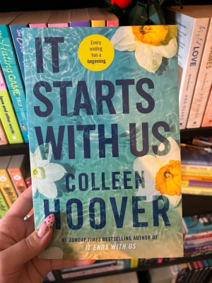 It Starts With Us - It Starts With Us av Colleen Hoover, på engelska. Den är läst men i mycket bra skick, inga skador på omslaget eller i boken!  Kolla min profil för liknande böcker! +bundle  rabatt!