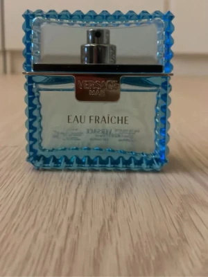 Versace Man Eau Fraîche parfym - Fräsch parfym från Versace i serien Man Eau Fraîche. Flaskan är fyrkantig med blått, räfflat glas och silverfärgad spraypump. Medföljer gör en matchande blå kartong med krokodilskinnsmönster och silverdetaljer. Perfekt för dig som gillar exklusiva dofter. Ca 46-47 ml kvar