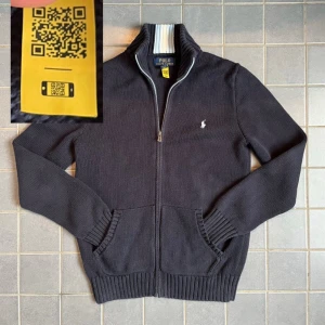 Mörkblå stickad ziptröja Polo Ralph Lauren - Polo Ralph Lauren zip up med schysst ljusbå häst och blå/vita detaljer. Fläckfri. ‼️Det är en tonårsstorlek large vilket gör den till en vuxen S/XS.‼️Den är 100% äkta och tillräckligt ny för att ha en QR-kod, så om den inte passar är det bara att sälja vidare.