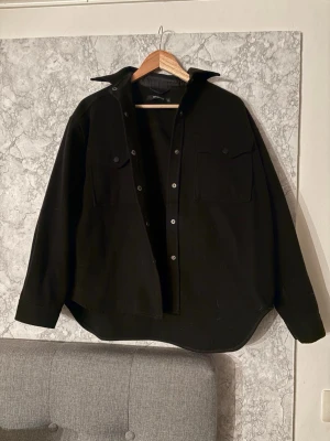 Svart overshirt - Svart jacka i storlek S och är en tunnare vårjacka. Jackan är i väldigt bra skick och använd ensta gånger