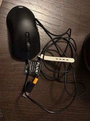 Svart och orange gamingmus Fnatic Flick 2 - Säljer en Fnatic Flick 2 gamingmus med sladd. Musen är svart på ovansidan och har en orange undersida med svarta detaljer. Ergonomisk form, scrollhjul och två knappar på sidan. Perfekt för gaming och datoranvändning.