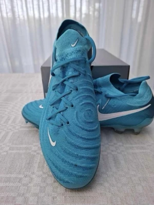 Nike fotbollsskor  - Säljer dessa snygga fotbollsskor Nike phantom Gx 2 elite fg blue fury. Använda endast en gång. Säljer då dom inte mer kommit till användning. Storlek 42. Kartong medföljer.