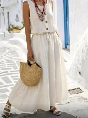 HELT NY OANVÄND Vit ärmlös klänning med och hålmönster i ryggen, M-L - HELT NY OANVÄND luftig och sval bohemisk vit långklänning i linne-look med ärmlös design, snyggt hålmönster I ryggen, knappar framtill och resår/knyt i midjan, samt fodrad under kjolen. Perfekt för varma dagar och har en avslappnad, bohemisk stil. Matchas snyggt med sandaler och halmväska. Polyester. Storlek: Large, men passar troligen även någon med Medium. Mått: Byst 102 cm, midja 72-104 cm, längd 129 cm.