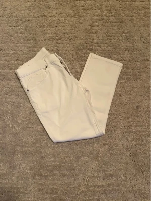 Dondup George jeans - Hej jag säljer ett par Dondup George jeans i riktigt snygg helvit färg perfekt för dig som vill ha ett par kvalitetsjeans med grym passform. Nypris ≈ 3000kr, mitt pris 599kr.  Skick: 9/10 Storlek: W34 små i storlek Midja: 40cm Lår: 25cm Ytterlängd: 90cm Innerlängd: 64cm  Skriv gärna om du vill ha fler bilder eller har frågor!