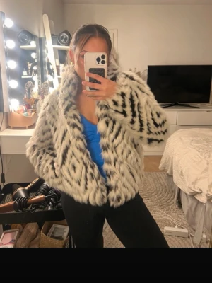 Vit och svart mönstrad pälsjacka - Säljer en fluffig pälsjacka med vit bas och svarta zigzag-mönster. Köpte jackan på Sellpy så den finns nog inte att få tag på någon annan stans. Säljs då jag har för många jackor💘