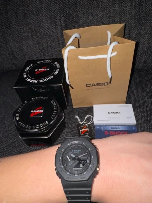Svart Casio G-Shock klocka - Säljer en svart Casio G-Shock klocka med digital och analog display. Klockan har robust design, resinarmband och kommer med originalförpackning, manual. Perfekt för dig som gillar stilrena accessoarer med funktion.