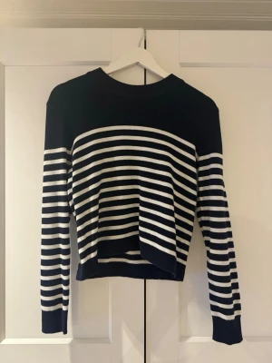 Randig vit/navy tröja med gulddetaljer  - Finstickad randig tröja med fina gulddetaljer på ena axeln. Passar perfa till våren och sommaren🌷