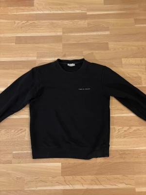 Svart sweatshirt från Tiger of Sweden - En stilren svart sweatshirt från Tiger of Sweden med diskret logga på bröstet. Tröjan har rund halsringning och långa ärmar. Perfekt för en clean och enkel look. Materialet känns mjukt och bekvämt mot huden.