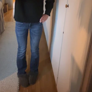 Blå bootcut jeans från Lee - Säljer ett par klassiska blå jeans från Lee med bootcut-passform. Jeansen har låg midja, fem fickor och snygga slitningar framtill. Perfekta för dig som gillar en tidlös denimlook med lite utsvängda ben. Nya utan lapp och inga tecken på användning! Hör gärna av er av frågor och pris kan diskuteras💕