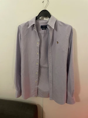Ljuslila skjorta från Ralph Lauren - Ralph Lauren skjorta i storlek ”Herr XS” skjortan har en trevlig ton av ljuslilla men även ljus blå. Priset är ej hugget i sten!