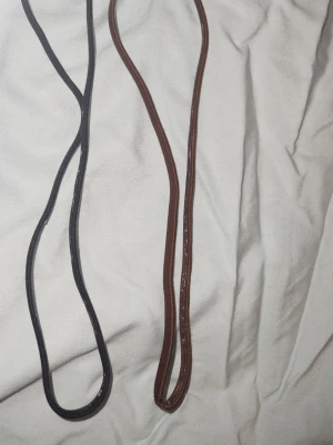 Hårband - Två stycken hårband i svart och brunt. Säljer då jag har för många. Väldigt bra när man tränar eller bara till frisyr. Har tvättat dem efter träning därav små bristningar i gummi-randen på insidan av dem. 