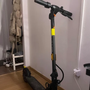 Svart elscooter med gula detaljer - Säljer en svart elscooter med gula reflexdetaljer och robust ram. Scootern har breda hjul, bekvämt handtag och tydlig display på styret. Perfekt för att ta sig runt i stan på ett smidigt och miljövänligt sätt.
