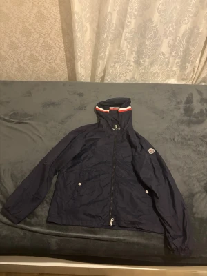 Moncler wimdbreaker - Säljer en blå Moncler windbreaker som knappt är använd och därför är i väldigt bra skick. Jackan har inga skador, fläckar eller slitningar och ser nästan ut som ny. Storlek M och sitter som den ska. Säljer den enbart eftersom den inte passar mig längre. Perfekt jacka för vår/sommar eller svalare dagar. Hör gärna av dig om du vill ha fler bilder eller undrar över något. 