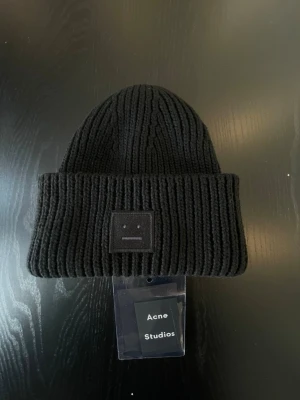 Svart Acne Studios Beanie - Svart Face Logo Beanie från Acne Studios. Ny med price tag. 56cm i omkrets.