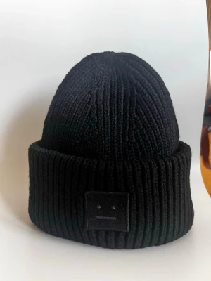 Svart ribbstickad mössa Acne Studios - Säljer en svart ribbstickad mössa från Acne Studios.Har använt mössan en gång,vill gärna ha ljusare färg som passar till min jacka 
