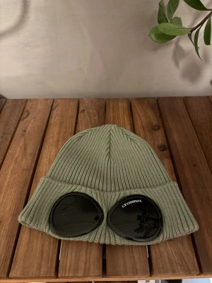 Grön ribbstickad mössa C.P. Company - Grön C.P company mössa, köpt på NK för ett år sen ungefär men har knappt använts! 