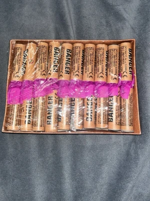 Banger 20 fyrverkeripjäser - Säljer en förpackning med 20 stycken Banger fyrverkeripjäser. Pjäserna är cylinderformade och bruna med svart text och har en lila tejp runt mitten. Kommer i originalförpackning med tydliga instruktioner på baksidan.
