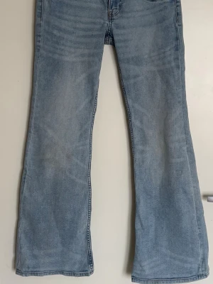 Ljusblå bootcut jeans low waist - Säljer ett par ljusblå bootcut jeans. Jeansen har en avslappnad passform över låren och utsvängda ben. Perfekta för en trendig och avslappnad stil.