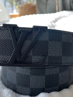 Bälte - Snygga svarta solglasögon med rundad form och klassisk design. Perfekta för att lyfta vilken outfit som helst och ger en cool vibe. Passar dig som gillar stilrena accessoarer med en tidlös känsla.