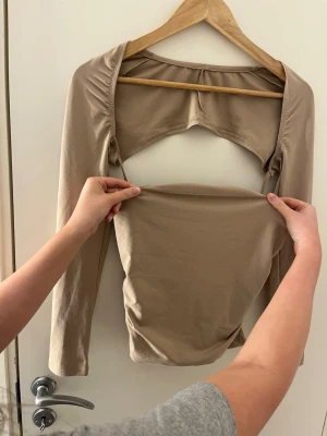 Beige omlottopp med öppen rygg - Jag vet inte värdet på den här har haft den sen 2016 vet inte vart den e köpt står inte heller det står inte att den e storlek 36 men jag vet att den är det 